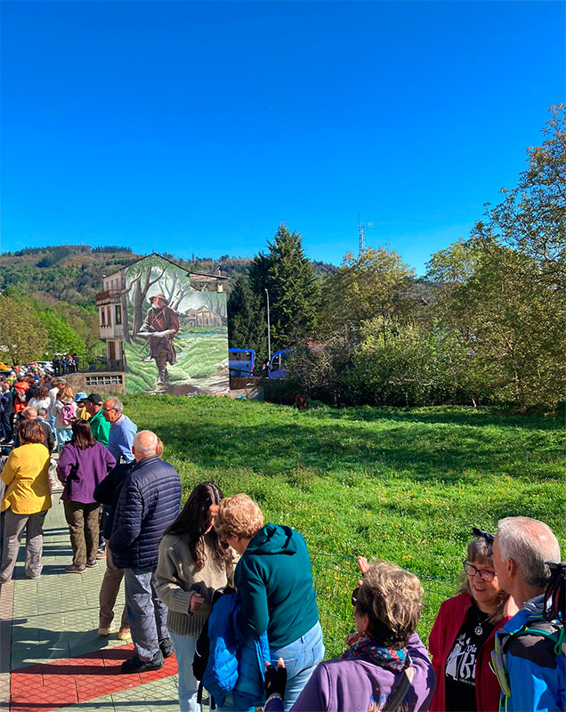 peregrinos en Becerreá, contemplando un mural del Camino de Künig