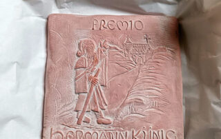 Una sencilla terracota, diseñada por la ceramista Marta Rivera, e inspirada en una antigua ilustración de la guía de Künig, para reconocer la labor de la hospitalidad en el peregrinaje.